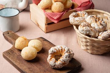 Brazil cheese bread and sweet biscuit and a cup of coffee on a table with beige tablecloth, selective focus.