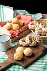 Brazil cheese bread and sweet biscuit and a cup of coffee on a table with green checkered tablecloth, selective focus.