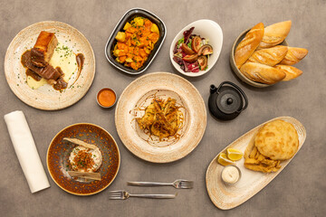dishes of typical Spanish gastronomy with a chic touch. Squid sandwich, patatas bravas, meatloaf, tomato salad, Russian salad with crunchies.