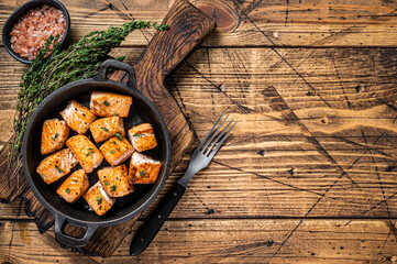 Roasted salmon or trout fish in a pan. Wooden background. Top View. Copy space