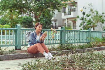 attractive asian woman using smart phone in park