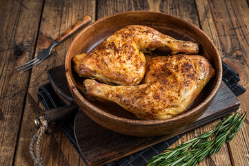 BBQ Grilled chicken legs in a wooden plate with herbs. wooden background. Top view