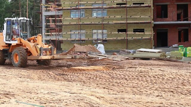 Heavy forklift work at construction site. Lifting and moving a reinforced concrete slab. Mice in the construction industry.