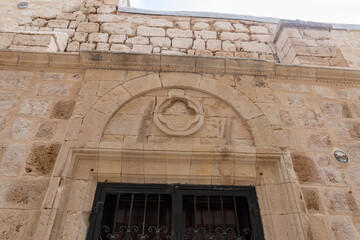 Stone  carved cross above the window of the St. Georges Greek orthodox cathedral in the old city of Acre in northern Israel