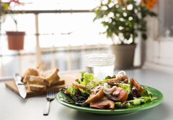 vegetable salad of greens, tomatoes and cucumbers on a green plate