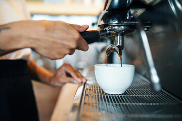 Closeup of female barista preparing espresso coffee