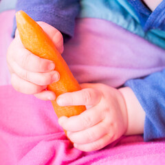 a child plays with a carrot