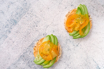Vegan sandwiches with avocado, yellow tomatoes on a white plate. Flat lay. View from above