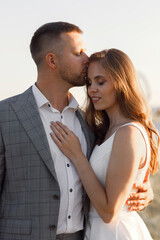 The bride and groom in the European style at sunset on the meadow. Wedding photo shoot in a field in nature.