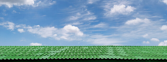 green roof with bright blue sky with clouds
