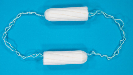 Cotton tampon blue background. Woman hygiene protection. Menstrual cycle, feminine care, menstruation and intimate products concept.