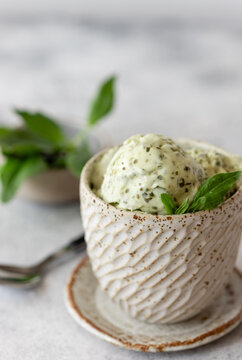 green spinach coconut ice cream in a ceramic bowl on a gray background. Healthy vegan dessert. vertical image. soft focus