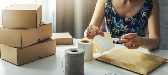 small online business owner preparing parcel shipping label at home for shipment delivery. banner