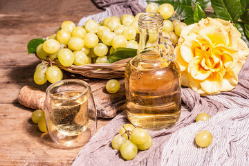 White wine and grape in a wicker basket on wooden table