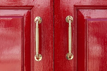 Gold aluminum door handle and red wood door