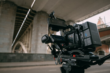 Professional film and video camera on the set. Shooting shift, equipment and group. Modern...