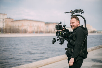 Director of photography with a camera in his hands on the set. Professional videographer at work on filming a movie