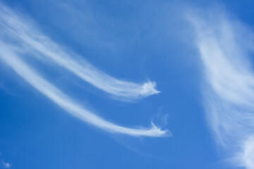 There are beautiful clouds in the sky on a clear day.