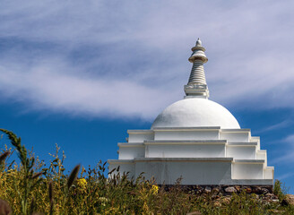 Buddhist Stupa on top of a mountain against the clear blue sky.