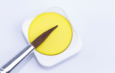 The image shows yellow watercolor isolated with brush on white background