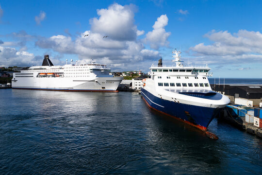 The photo shows two large ferries on the island of Orkney, tied up to a pier