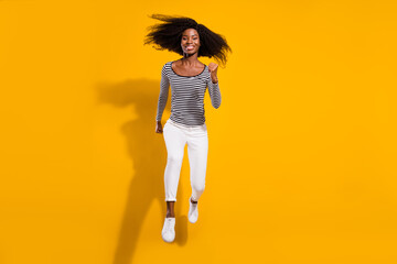 Fototapeta na wymiar Full length body size photo woman jumping high running fast isolated vivid yellow color background