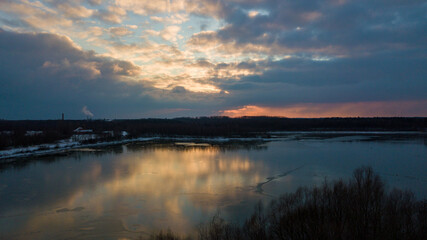 Aerial view of a beautiful and dramatic sunset over a forest lake reflected in the water, landscape drone shot. Blakheide, Beerse, Belgium. High quality photo