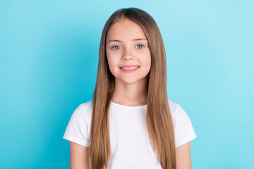 Photo of optimistic brown hair little girl wear white t-shirt isolated on blue color background