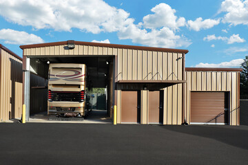 Generic large brown warehouse storage garage with rear of large tall brown bus