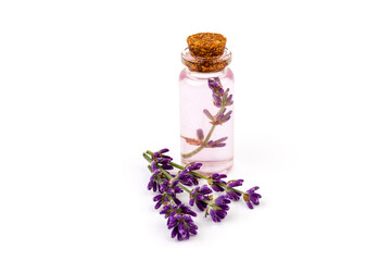 Glass bottle of Lavender essential oil with fresh lavender flowers on white background,...