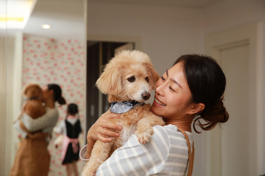 Cute young woman kisses and hugs her puppy, love between onwer and dog,animal lover concept
