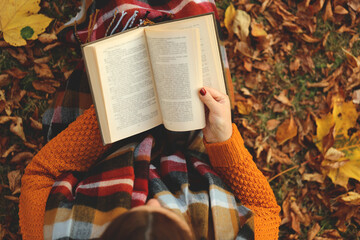 Reading books. Learning and knowledge concept. A girl with an open book in her hands in an autumn...