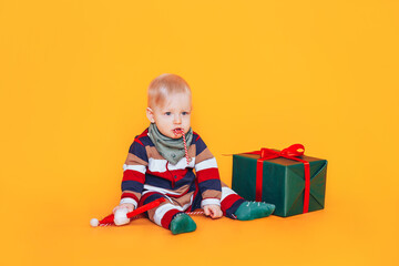 Little boy with candy and gift in front of yellow background.
