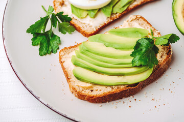Toast with avocado and egg on white plate. Top view. Healthy breakfast