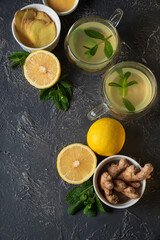Ginger tea with mint, lemon and honey on concrete background. Top view