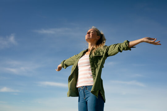 Happy caucasian woman having fun,standing at the beach with open arms