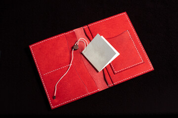 Open leather red purse with pockets on a dark background.