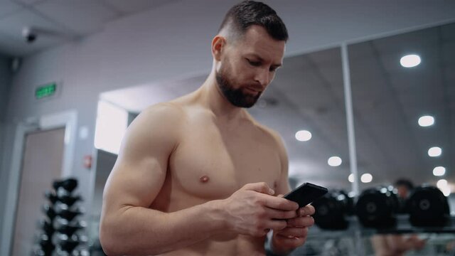 The Focused Athlete Writes Down On The Phone The Number Of Exercises Performed, The Weight Lost And The Calories Burned. Intense Masculine Energy. Healthy Lifestyle. Sport Concept