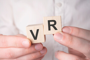 VR concept. Man holding wooden cubes with VR sign