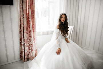 Fototapeta premium Luxury bride in white dress posing while preparing for the wedding ceremony