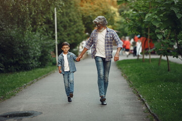 Grandfather with grandchild walking in a summer park