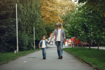Grandfather with grandchild walking in a summer park