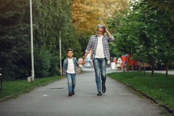 Grandfather with grandchild walking in a summer park