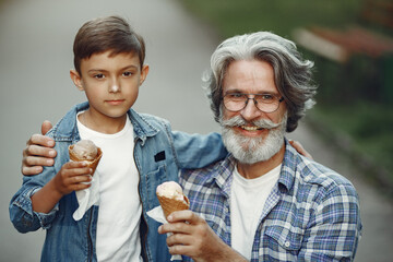Grandfather with grandchild walking in a summer park