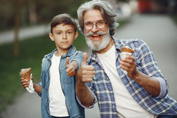Grandfather with grandchild walking in a summer park