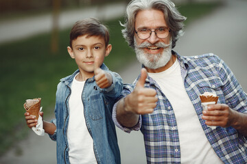 Grandfather with grandchild walking in a summer park