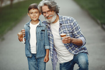 Grandfather with grandchild walking in a summer park