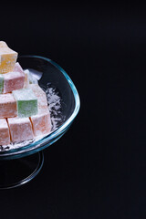 Turkish Delights in a glass bowl isolated on black background. Kurban bayrami (eid al adha), ramazan bayrami (eid al fitr) story background photo. iyi bayramlar - eid mubarak