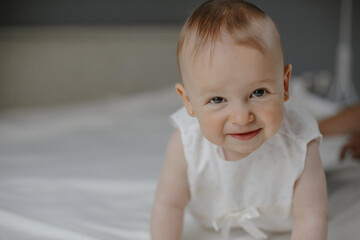 Portrait of smiled wondered little cute baby girl with big eyes crawling on the white background,...