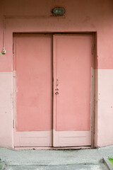 Old wooden skewed pink doors.